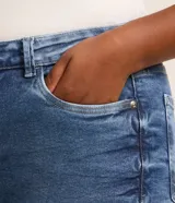 Pantalón de jean skinny azul con deshilachados, tiro alto y ajuste elástico en la cintura. Confeccionado en algodón BCI.