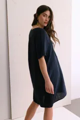 Vestido corto color arena de lino, con cuello en V y mangas cortas.