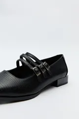 Zapato tipo Mary Jane de charol sintético color rojo, con punta cuadrada y triple tira con hebillas.