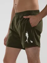 Short de baño negro con bordado de enredadera blanca en la pierna izquierda. Cuenta con cintura elástica con cordón ajustable, bolsillos laterales y bolsillo trasero con cierre. Incluye suspensor de malla fina hipoalergénico.