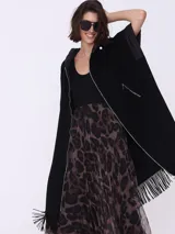 Tapado negro sin mangas con flecos en el ruedo y cierre frontal con cremallera.