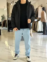 Campera 2 en 1 impermeable de color negro, con diseño con capucha y cierre frontal completo.
