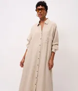 Vestido midi de lino y viscosa color beige, de corte recto y largo extendido, con cuello camisero, cierre frontal de botones, bolsillo ojal en el pecho y mangas largas.