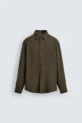 Camisa relaxed fit color verde militar, confeccionada en tejido con mezcla de modal. Tiene cuello solapa, manga larga con puño abotonado, bolsillo plastrón en el pecho y cierre frontal de botonadura.