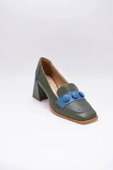 Zapato de cuero verde con aplique de cuero azul y botones forrados.