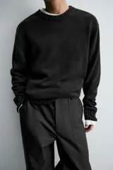 Jersey de corte relajado confeccionado en hilatura de algodón con efecto lavado. Presenta cuello redondo, manga larga y acabados en rib en cuello, puños y bajo.