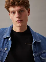 Remera de algodón de corte regular con cuello redondo y manga corta. Presenta un diseño minimalista con el logo de la marca estampado en pequeño en el pecho y un gráfico grande en la parte trasera.