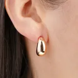 Aros dorados con forma de gota y un pequeño detalle de strass.
