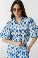 Camisa de lino estampada en blanco y azul con cuello camisero, botones de nácar y mangas abullonadas hasta el codo.