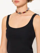 Top negro ajustado al cuerpo, sin mangas, con escote redondo profundo tanto en el frente como en la espalda.