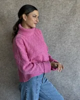 Sweater de lana color crudo con cuello alto y diseño trenzado.