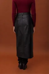 Falda larga de cuero ovino con efecto gastado, diseño tipo jeanera con bolsillos frontales y traseros, y aberturas laterales.
