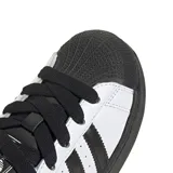 Championes Adidas Superstar II, diseño clásico con exterior de cuero blanco, tres tiras laterales negras, puntera de goma reforzada y suela de goma negra.