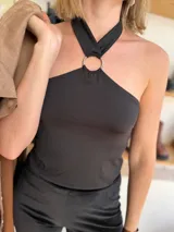 Top negro con diseño halter y argolla metálica en el centro.