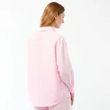 Camisa de lino mezclado color rosado, con cuello camisero, manga larga con puños abotonados y cierre frontal con botones.