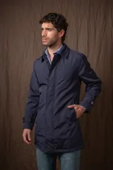 Trench azul marino de nylon, con cuello clásico, cierre frontal con botones y bolsillos laterales.