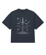 Remera oversize de algodón con estampa frontal en color blanco que representa una espada clavada en una roca, rodeada de estrellas, nubes y aves.