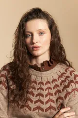 Sweater de tejido jacquard con diseño geométrico en color marrón sobre base beige, de cuello redondo y manga larga con puños ajustados.