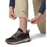 Pantalón convertible de senderismo color beige, con perneras desmontables mediante cremallera que permiten transformarlo en shorts. Cuenta con bolsillos laterales y traseros, diseñado con tecnología de protección solar.