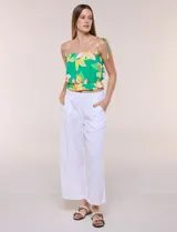 Pantalón crop de lino y rayón, con diseño wide leg de corte holgado, estampado tropical de hojas en tonos verde, azul y marrón sobre fondo blanco. Cuenta con pretina trasera elastizada y bolsillos delanteros.