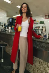 Abrigo largo de Zara confeccionado en mezcla de lana color rojo, con cuello de solapa, manga larga, bolsillos con solapa en el frente y cierre frontal de botones negros.
