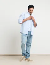 Camisa celeste a rayas verticales, de corte clásico, con cuello button-down y manga larga.