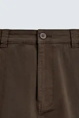 Pantalón cargo de corte relajado confeccionado en tejido de algodón con elasticidad. Presenta bolsillos laterales tipo cargo con solapa en las perneras, bolsillos frontales y bolsillos traseros de doble vivo. Cierre frontal con cremallera y botón.