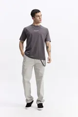 Remera de manga corta color gris oscuro, con escote redondo, ajuste regular y estampado frontal con la palabra "POSITIVE" en estilo graffiti.