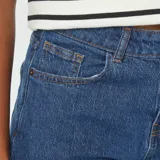 Short de jean azul oscuro, tiro alto, con corte recto y largo hasta medio muslo.