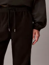 Jogger Calvin Klein de tejido polar color negro, con corte regular, cintura elástica con cordón ajustable y puños elásticos en los tobillos.