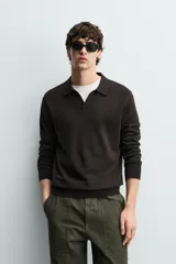 Sweater polo de punto de mezcla de algodón en color negro, con cuello solapa, abertura frontal y mangas largas con acabado en rib.