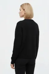 Sweater negro de punto liso, de corte holgado, con cuello redondo a la base y mangas largas.