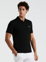 Polo negra de piqué de algodón orgánico, corte recto, cuello con solapa y logo bordado en el pecho.