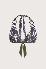 Top de bikini estilo halter con estampado geométrico en tonos verde oliva y azul sobre fondo blanco. Presenta detalles de argollas circulares en carey en los tirantes superiores y cierre de lazo en la espalda.