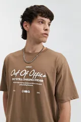 Remera celeste de manga corta con cuello redondo y estampado con la frase "Out of Office All Chasing Dream" en color negro.