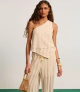 Pantalón recto color beige con textura, confeccionado en algodón BCI más sostenible, con cintura alta elástica y lazo de ajuste.