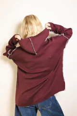 Sweater de punto color marrón con capucha, diseño holgado y costuras a la vista con pespunte a contratono. Presenta etiqueta con logo en el centro del pecho.