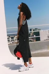 Enterizo de algodón y spandex color negro lavado, de corte holgado con entrepierna caída y tirantes finos. Presenta bolsillos laterales amplios.