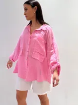 Camisa negra de manga larga con cuello clásico y cierre frontal con botones.