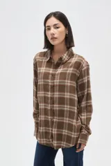 Camisa de algodón con estampado de cuadros en tonos marrones y blancos, de corte holgado, manga larga y cierre frontal con botones.