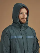 Campera de abrigo azul marino con capucha, cierre frontal con botones y cremallera, múltiples bolsillos y forro interior naranja.