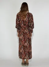 Vestido largo azul con estampado abstracto en blanco y negro, corte recto y mangas largas abullonadas.