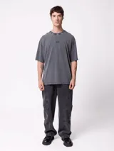 Remera oversize de color gris oscuro con efecto acid wash, mangas cortas y cuello redondo. Cuenta con un pequeño estampado frontal con la inscripción "DIXIE".