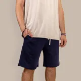 Bermuda deportiva azul marino de algodón, con cintura elástica ajustable con cordón, bolsillos laterales y bolsillo trasero.