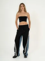 Pantalón de jean azul con corte jogger, cintura elastizada con cordón de ajuste y detalle de tres rayas blancas verticales en los laterales.