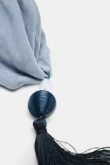 Bolso de mano tipo pouch de ante color celeste, con cierre imantado, bolsillo interior con cremallera y detalle colgante de borla con piedra.
