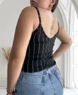 Musculosa negra con tirantes finos y estampado de rayas verticales blancas.