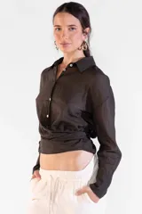 Camisa de manga larga color marrón, con cuello camisero, botones frontales nacarados y tiras cruzadas en la cintura.