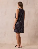 Camisón corto negro con estampado de lunares blancos, escote en V con botones y detalle plisado en el pecho.