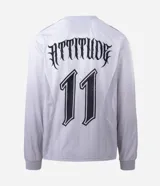 Remera de manga larga estilo deportivo con corte boxy, confeccionada en poliéster. Presenta cuello redondo, paneles laterales en tejido texturizado y estampados gráficos estilo tribal y lettering gótico en el frente.